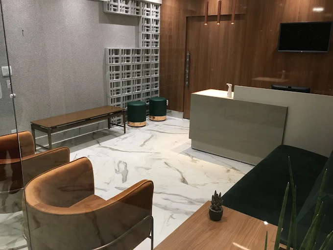 Recepção do consultório, com balcão em mármore e ambiente em tons amadeirados