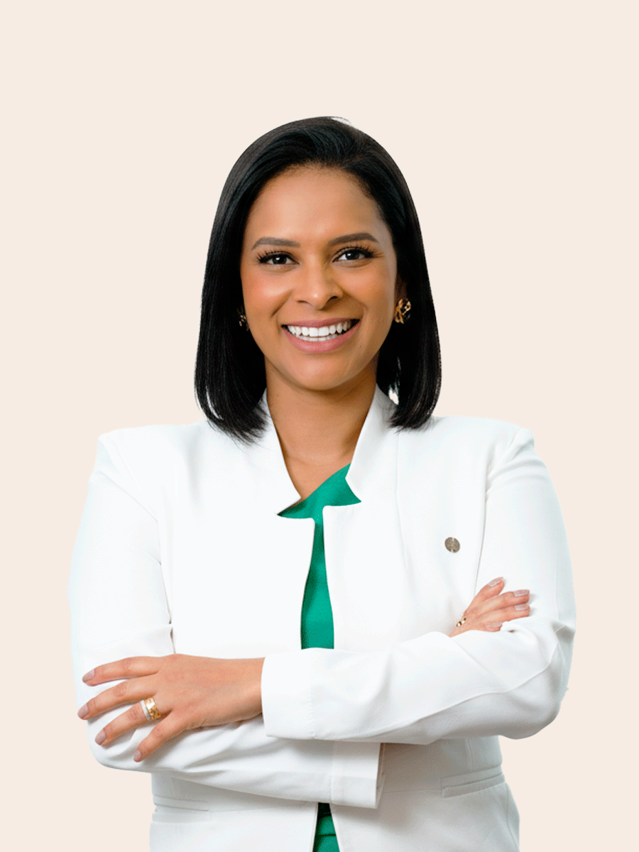 Dra. Lourena Lima sorrindo, de jaleco branco e braços cruzados